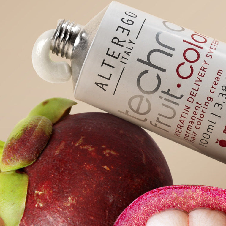 tube of Alter Ego Italy Technic Fruit Color hair coloring system with a mangosteen fruit on a beige background
